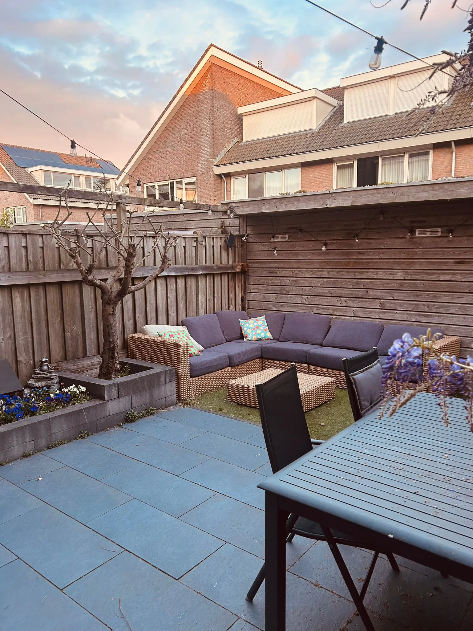 De achtertuin met een loungebank en bestrating